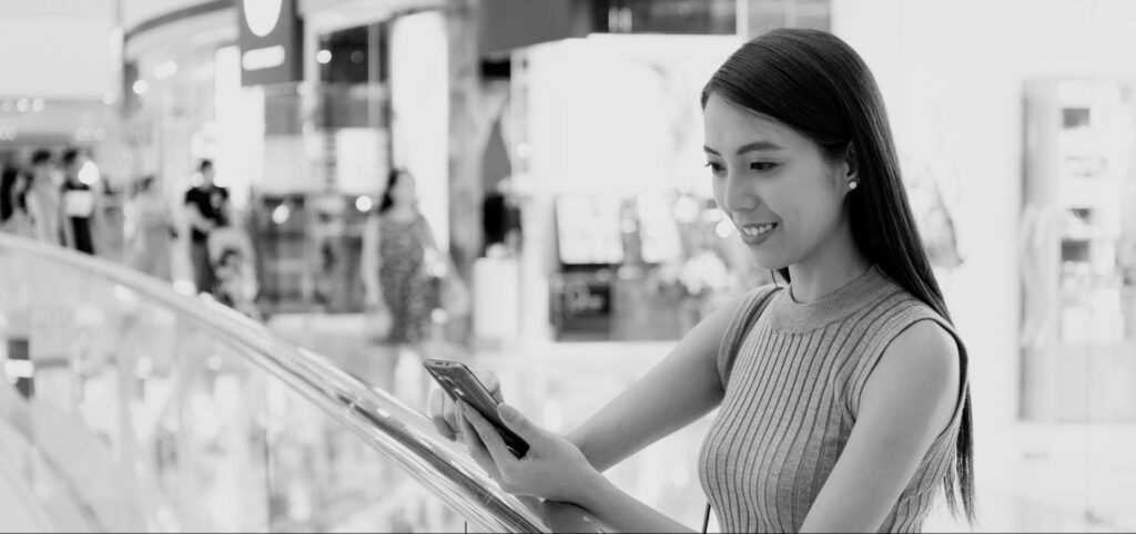 Customer viewing phone in a retail environment, feature image for an article on DSC vs Marketplace